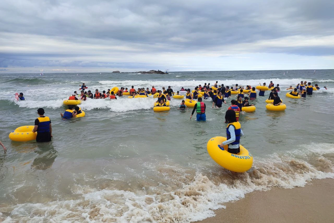 Пляжный отдых: купание в море, толпа и желтые круги